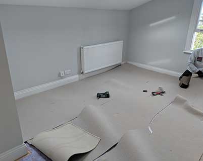 Removing the carpet to expose the subfloor
