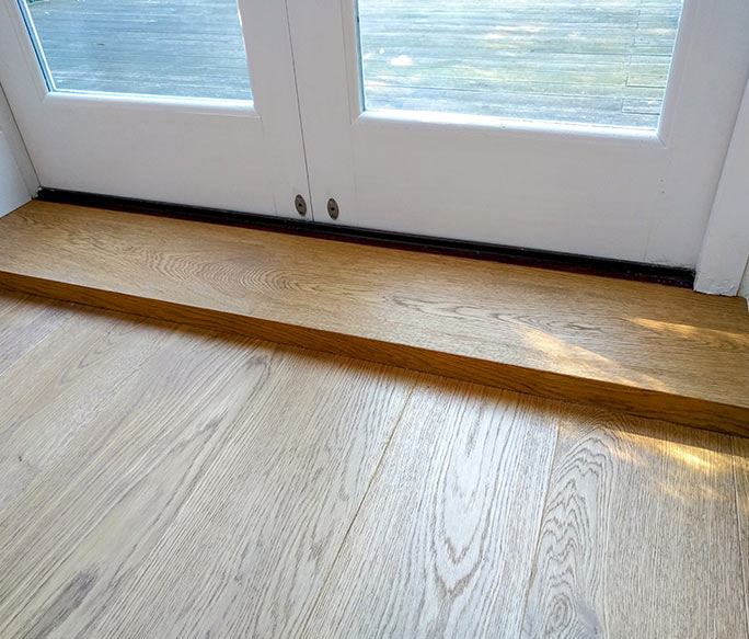 Custom oak step transition for a raised patio door threshold #CraftedForLife