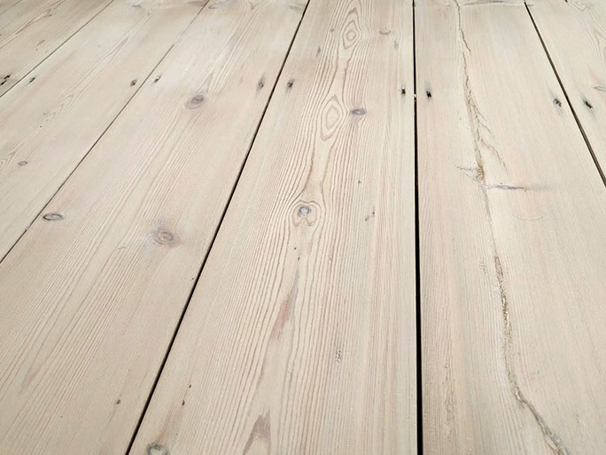 Lightly sanded pine floorboards with visible expansion gaps running between the planks, showing the natural wood grain and knots #CraftedForLife