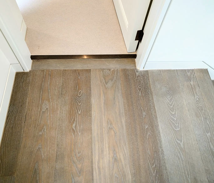 Oak herringbone floor with perimeter border meeting stone tiles #CraftedForLife