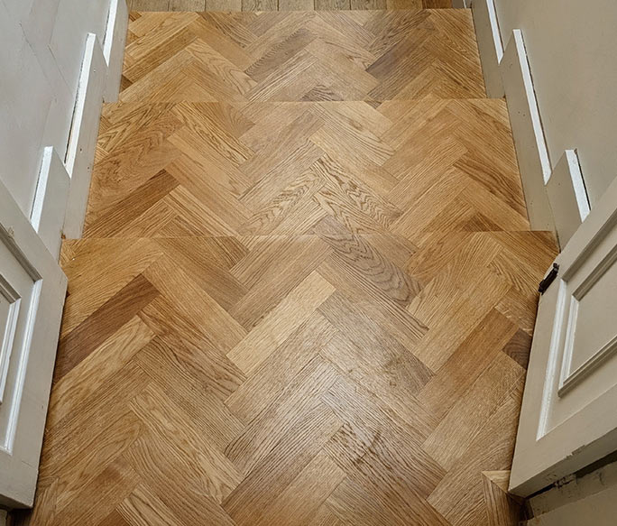 Oak herringbone parquet transition with mitred riser edges #CraftedForLife