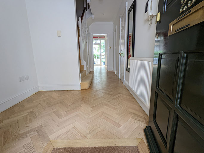 Raw natural oak herringbone parquet with a simple single row border #CraftedForLife