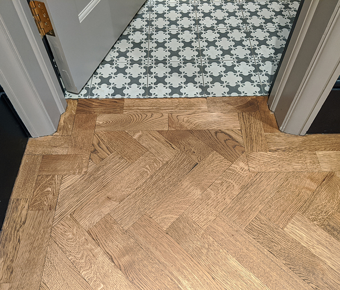  Transition from oak parquet floor to hallway tiles beneath the door line #CraftedForLife